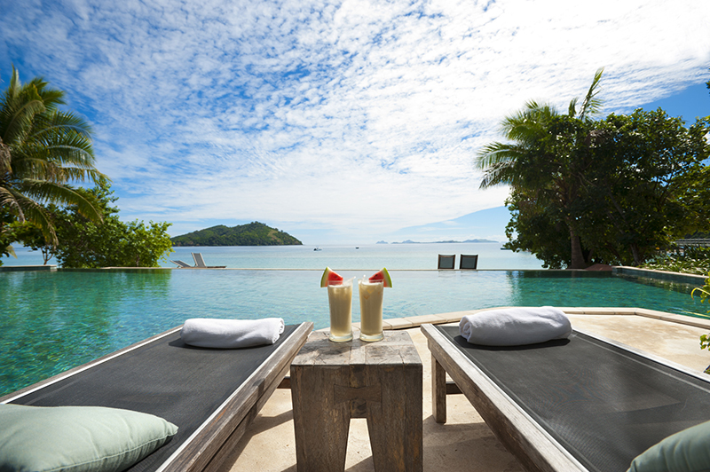 A lounge beside the pool with cocktails on table